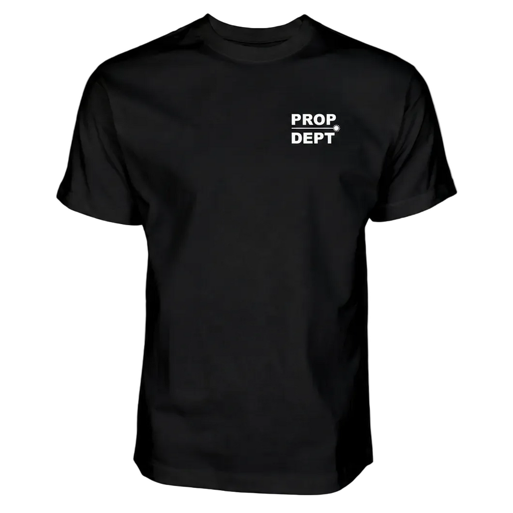 A black short-sleeve crewneck t-shirt with 'PROP DEPT' printed in white block letters and a white arrow on the left chest, displayed on a solid white background.