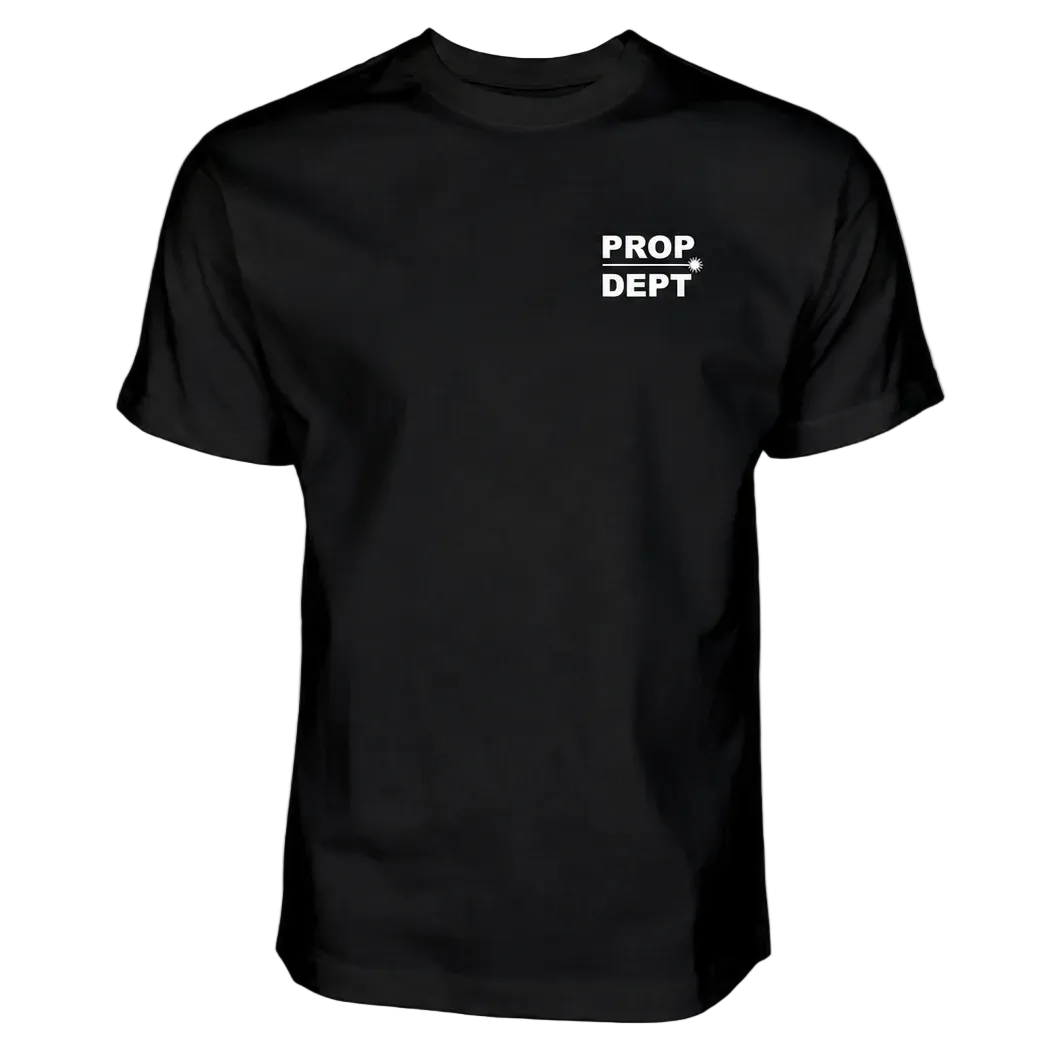 A black short-sleeve crewneck t-shirt with 'PROP DEPT' printed in white block letters and a white arrow on the left chest, displayed on a solid white background.